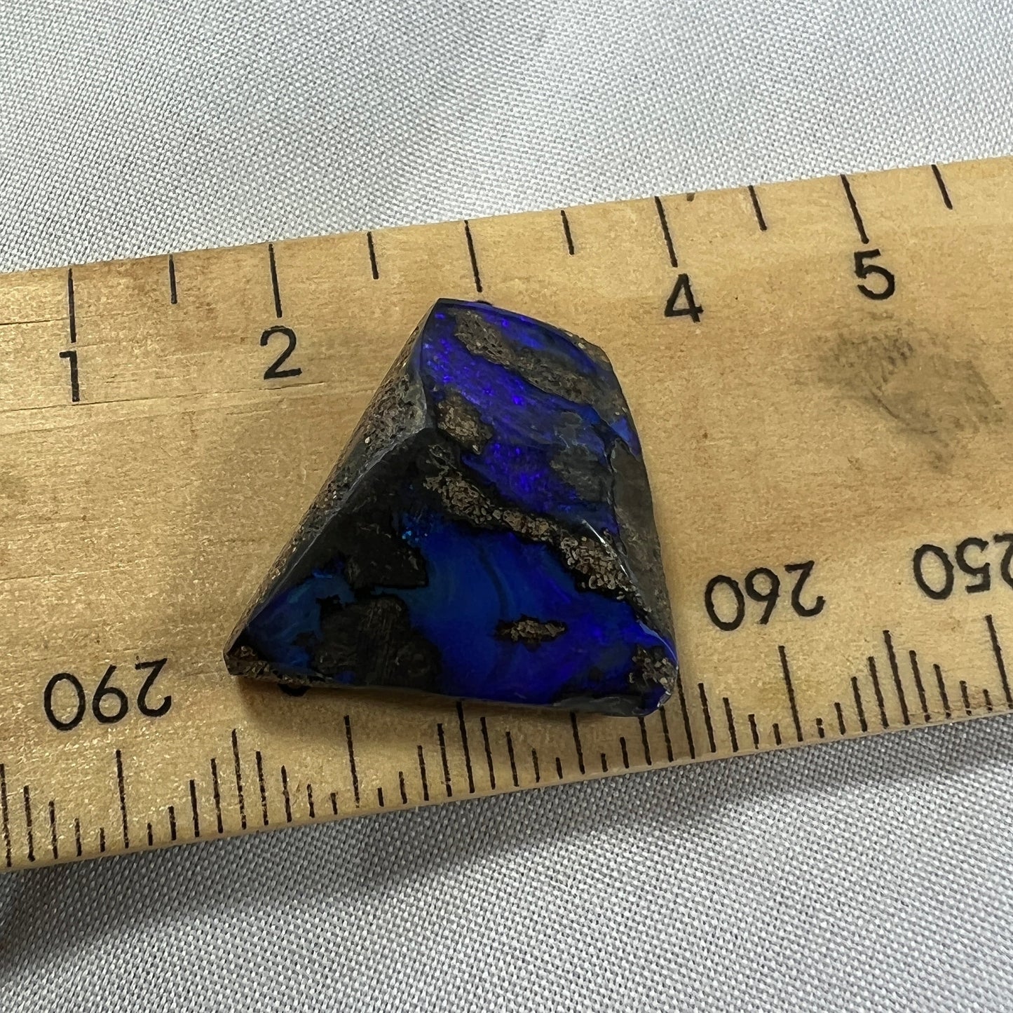 An unusual shaped piece of boulder opal with stunning blues throughout.