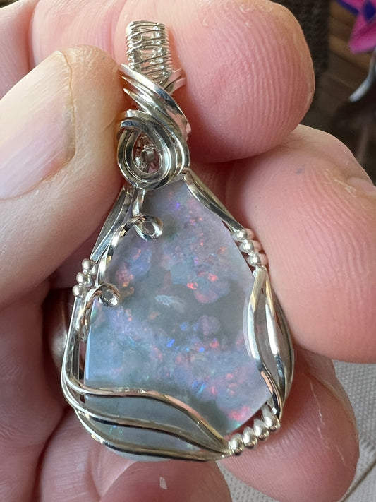 Unique Coober Pedy grey base opal on a silver hand made wire pendant. Nice colours.