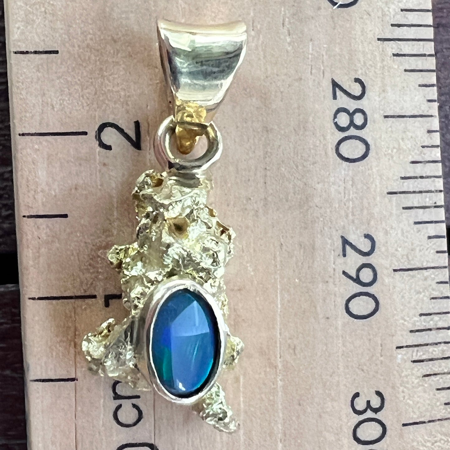 Pure solid gold nugget pendant from Western Australia. Perfectly set with a 18ct gold bale. Set beautifully with a solid black opal from Lightning Ridge.
